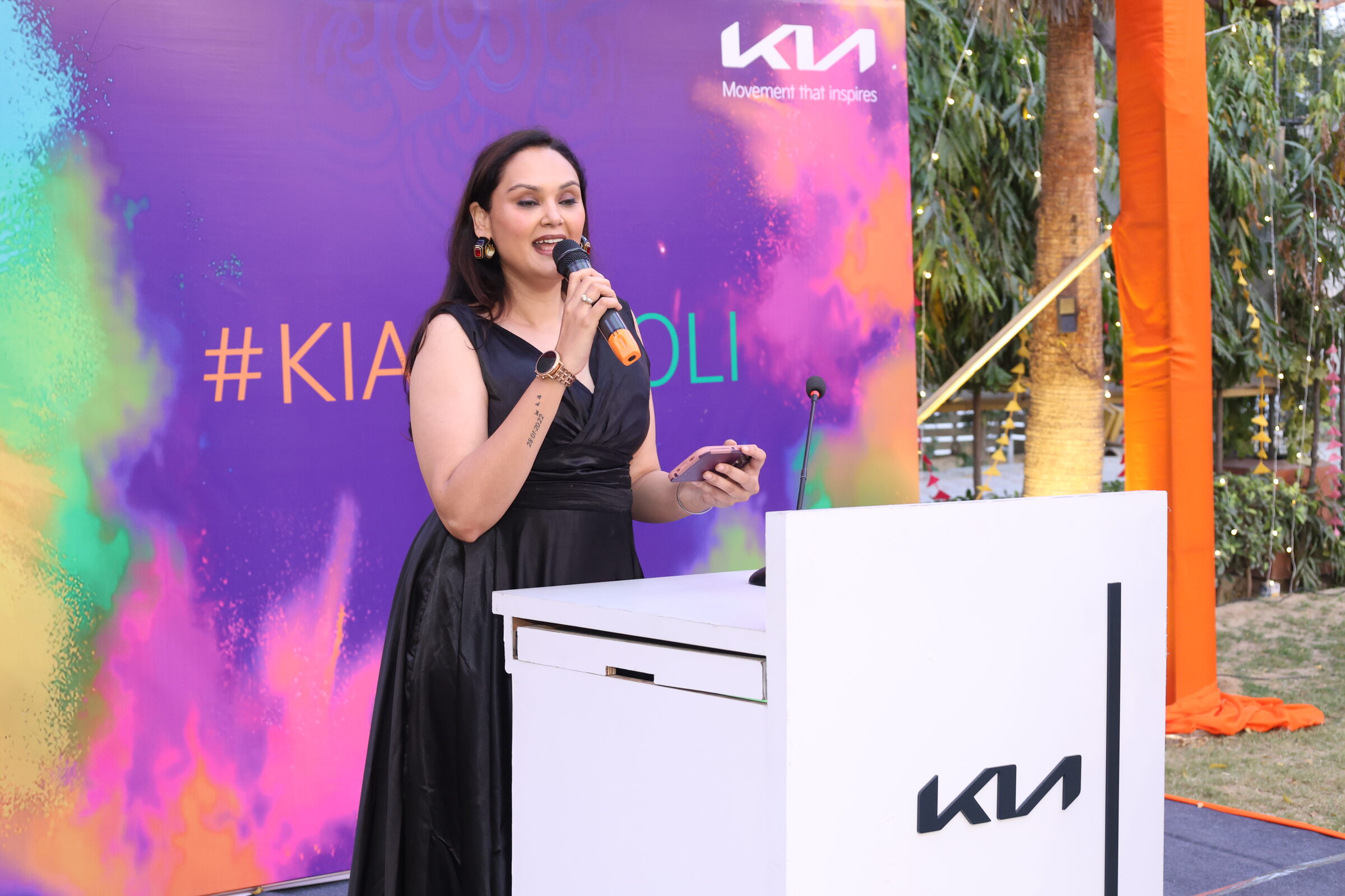 A presenter speaking at a colourful corporate event