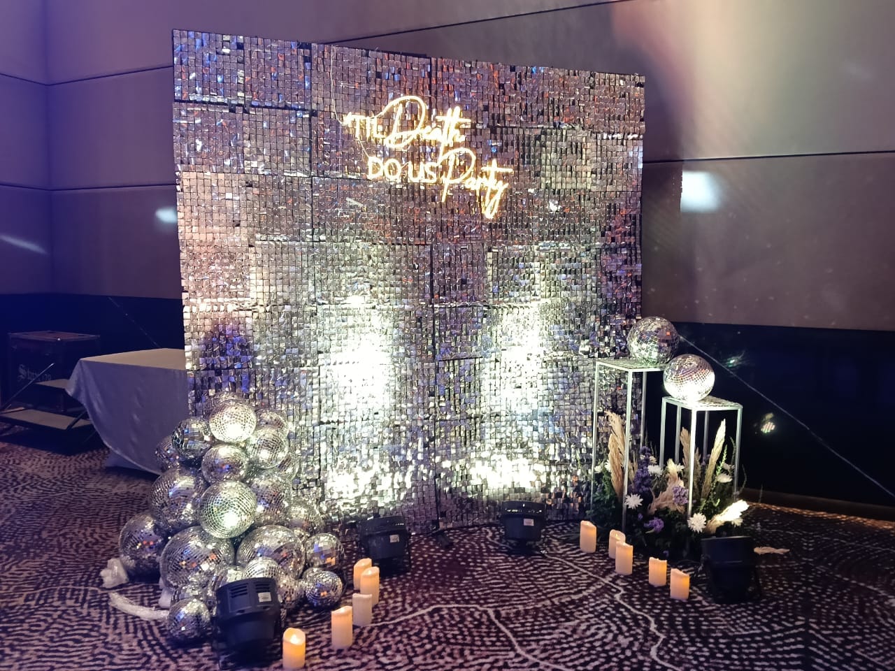 A reflective evening event backdrop with flowers and candlelight