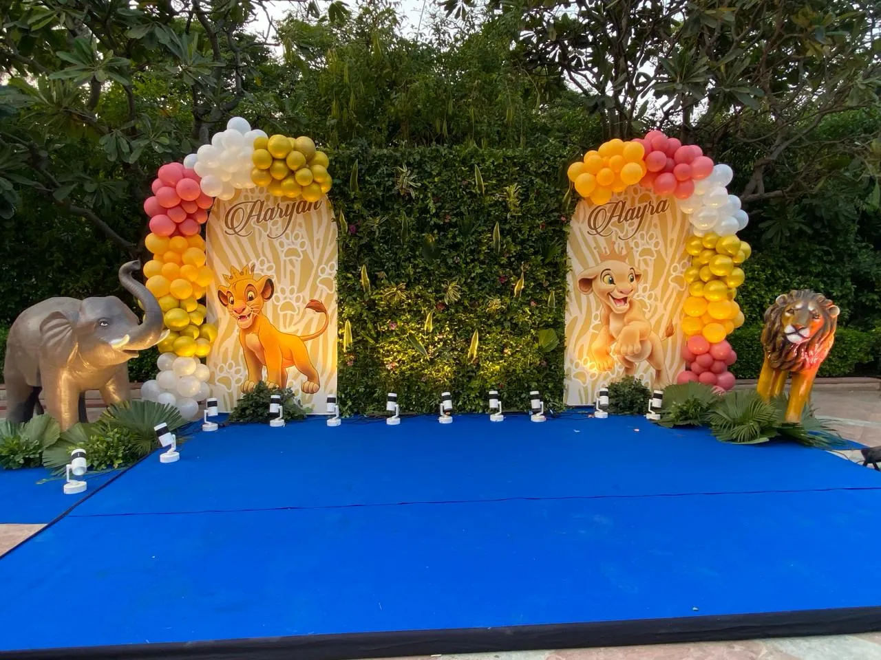 A bright birthday stage with balloon arches and themed character details