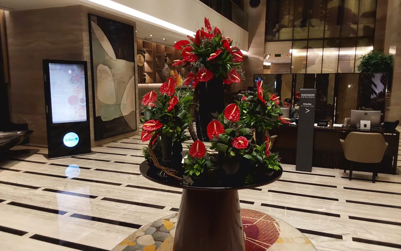A red floral arrangement styled in a workplace lobby