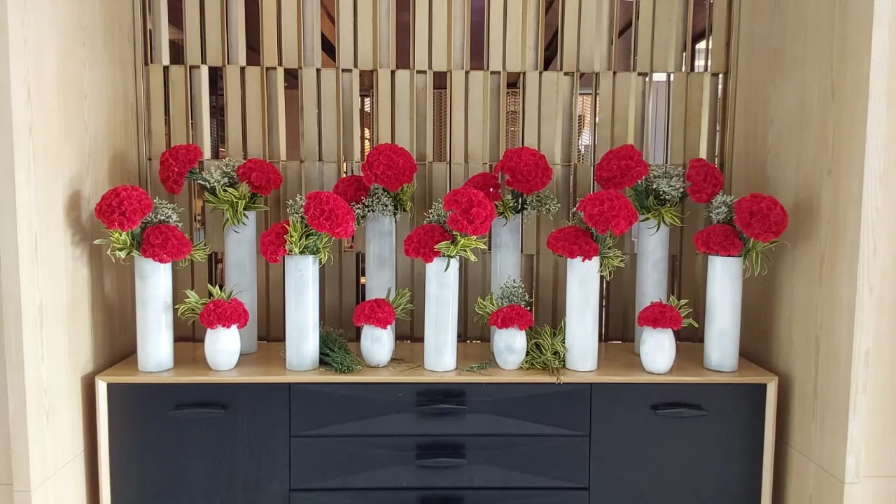 Floral vases arranged along a workplace console