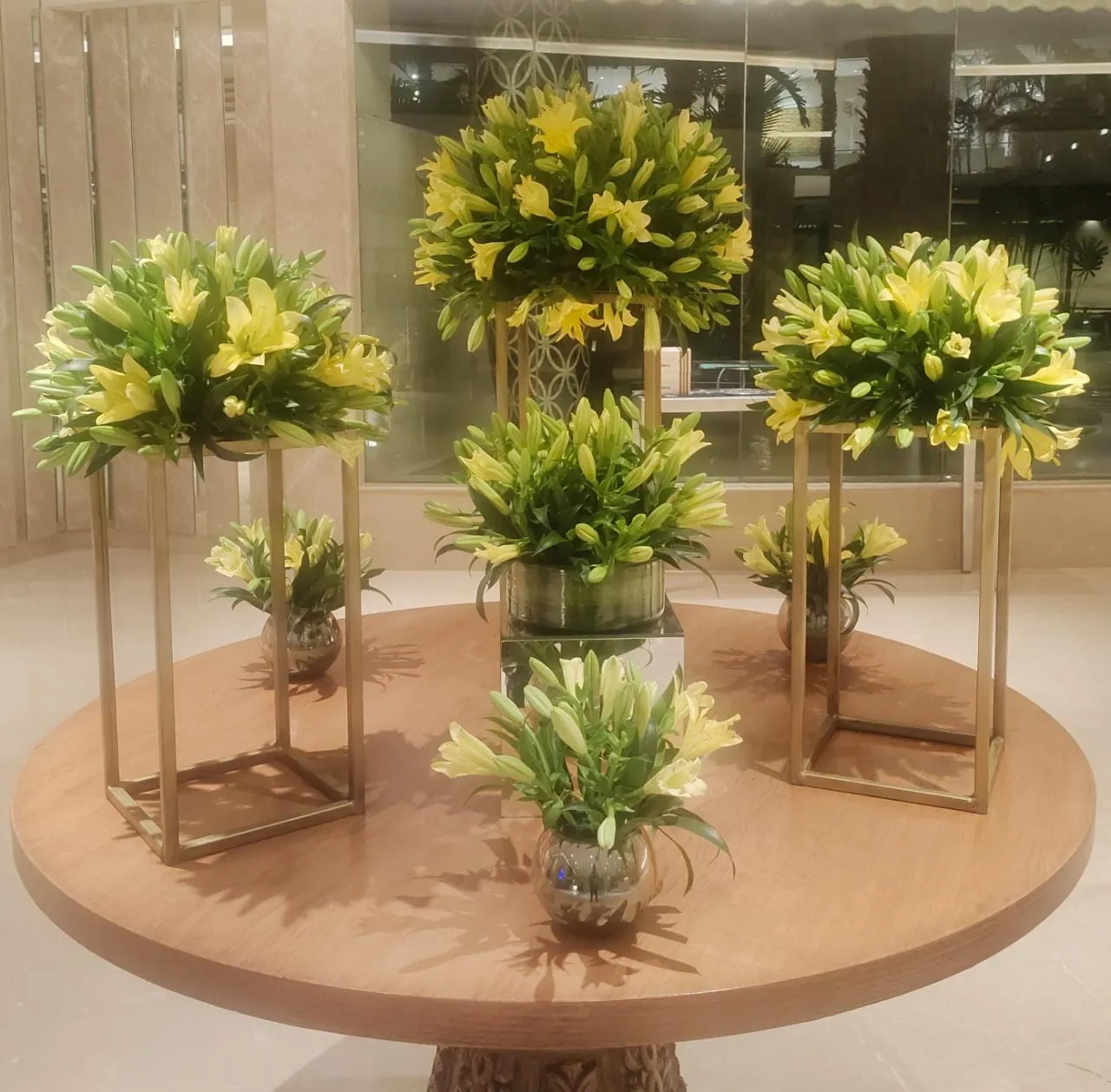 A round table styled with tall greenery in a common area