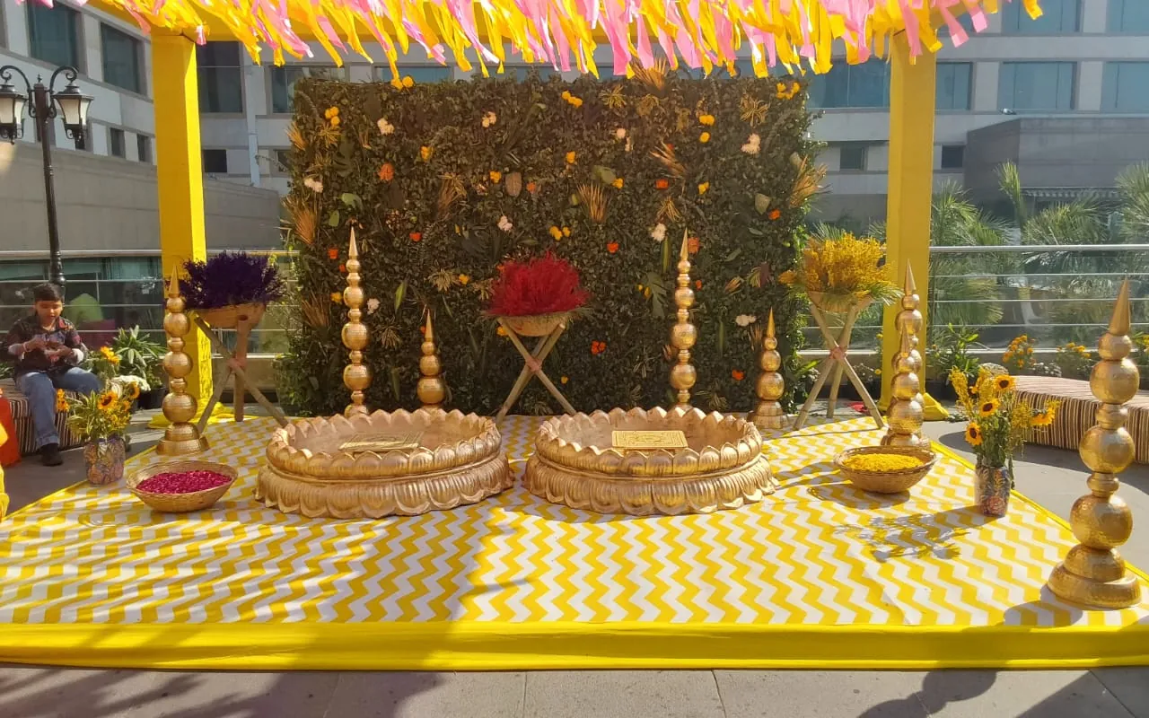 A gold-toned birthday stage with flower and balloon details