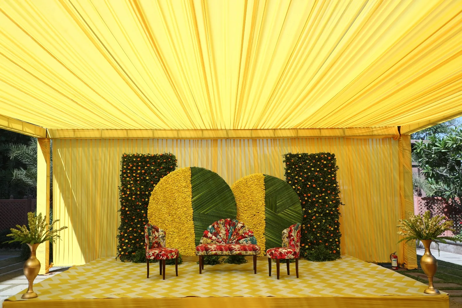 A yellow and green floral stage set for a daytime function