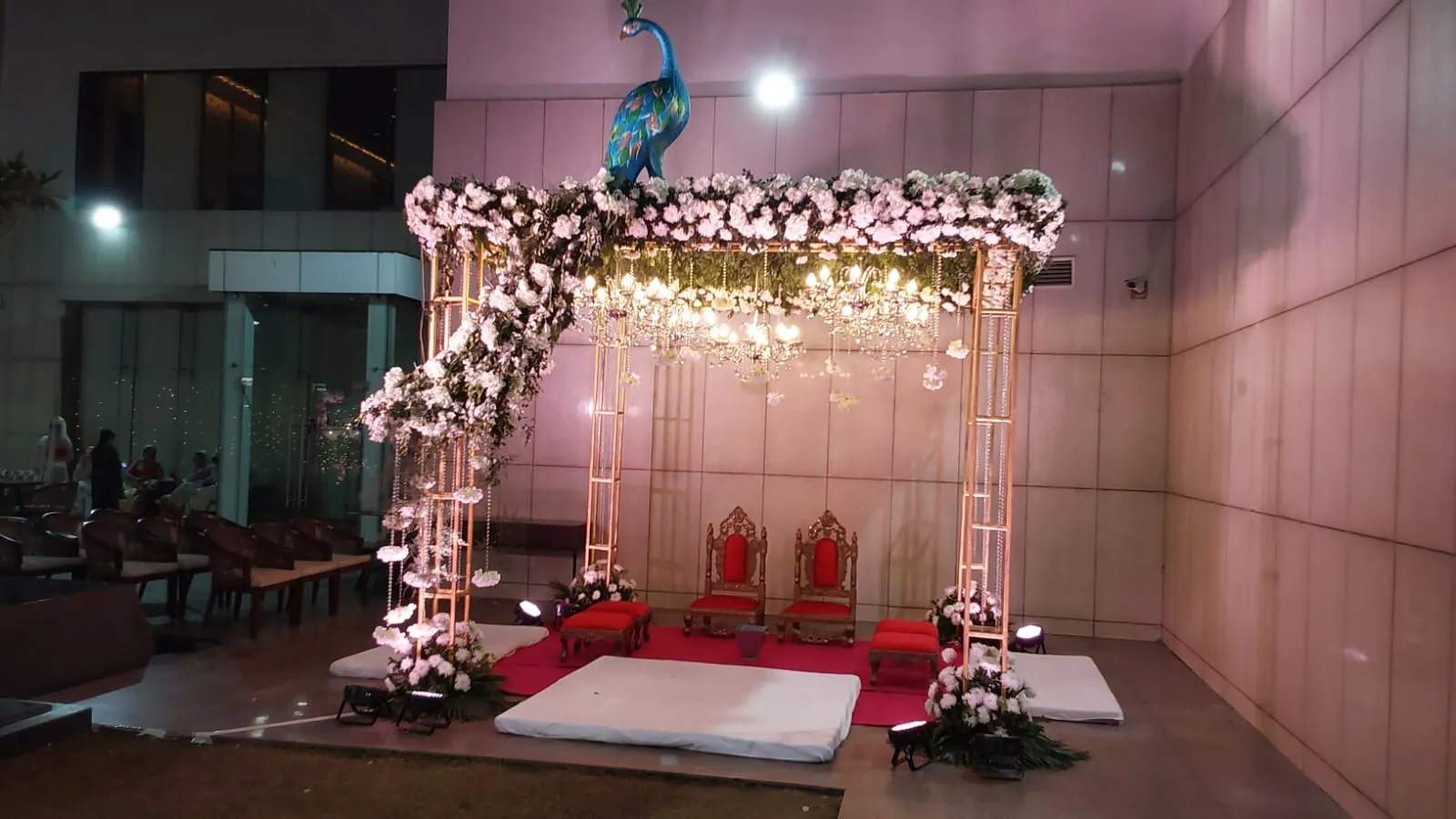 A wedding stage lit in pink and gold before guests arrive