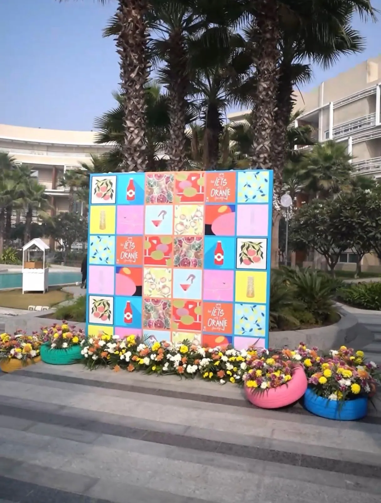 A printed panel wall used as a photo backdrop beside a pool