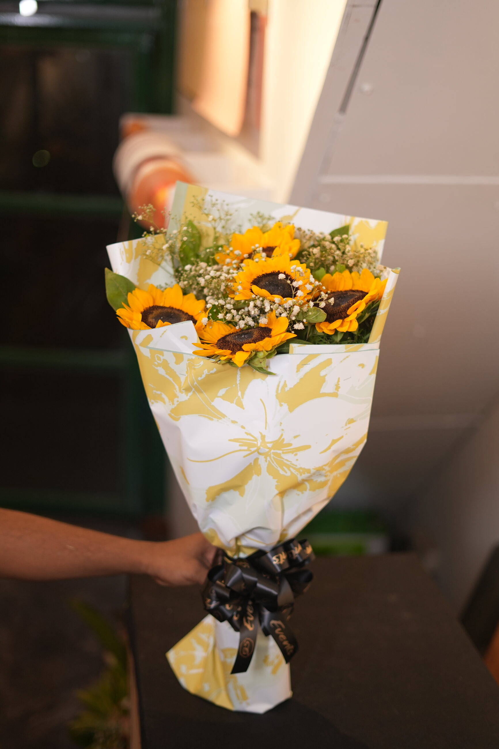 A sunflower bouquet wrapped in patterned paper