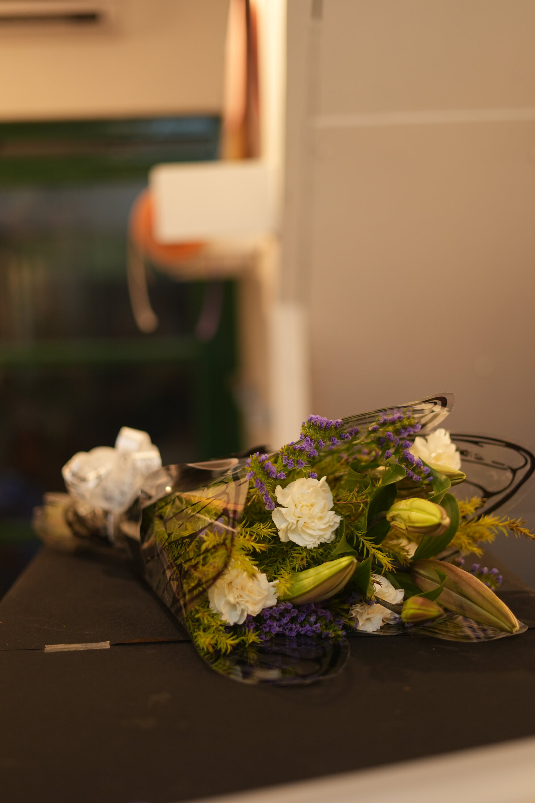A white and green bouquet with a modern black wrap